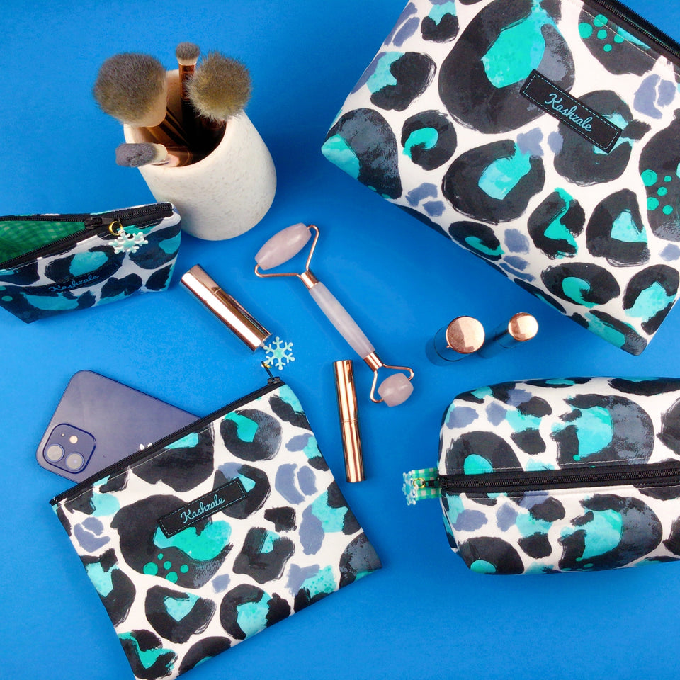 Image of Aqua and Grey Leopard Print cosmetic bags on a blue background.